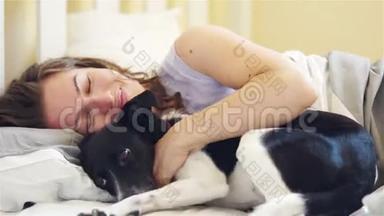 沉睡的微笑的女人和她的狗在床上。 高清高清